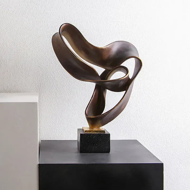 Fitlybuy Vida modern abstract resin sculpture in bronze on a black base, displayed on a black pedestal.
