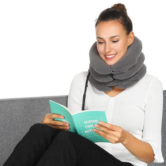 Woman reading a book while wearing a grey, multi-layered Fitlybuy cervical traction neck support device.