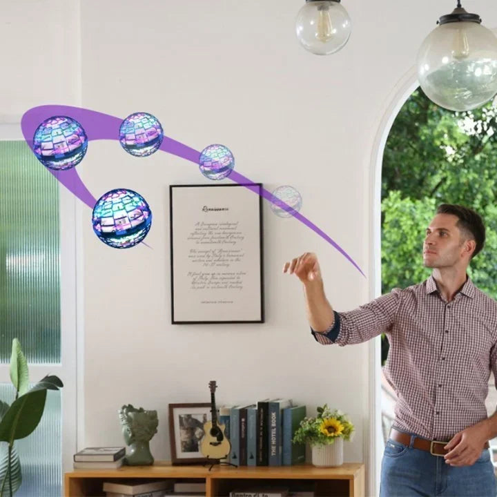 Man throwing a glowing Fitlybuy boomerang hover ball, showing its spherical shape and AeroGlide flight path in a room.