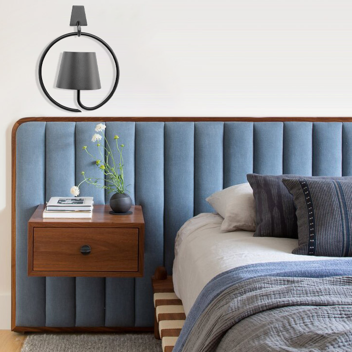 Fitlybuy LumiCord: Matte black circular wireless LED hanging lamp mounted above a modern blue upholstered headboard.