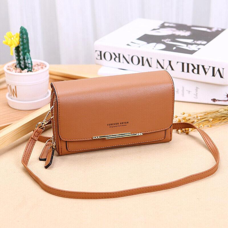 Tan leather Fitlybuy crossbody bag with gold hardware, zipper closure, and long strap on a table with decor.
