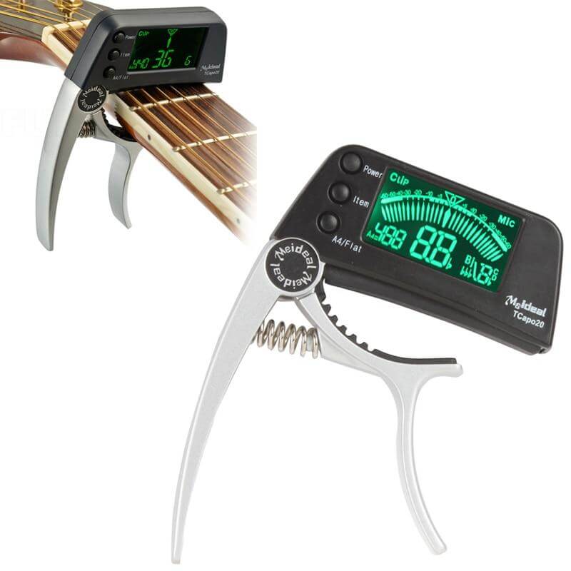Fitlybuy 2-in-1 silver guitar capo with a black digital tuner screen clamped onto an acoustic guitar neck.