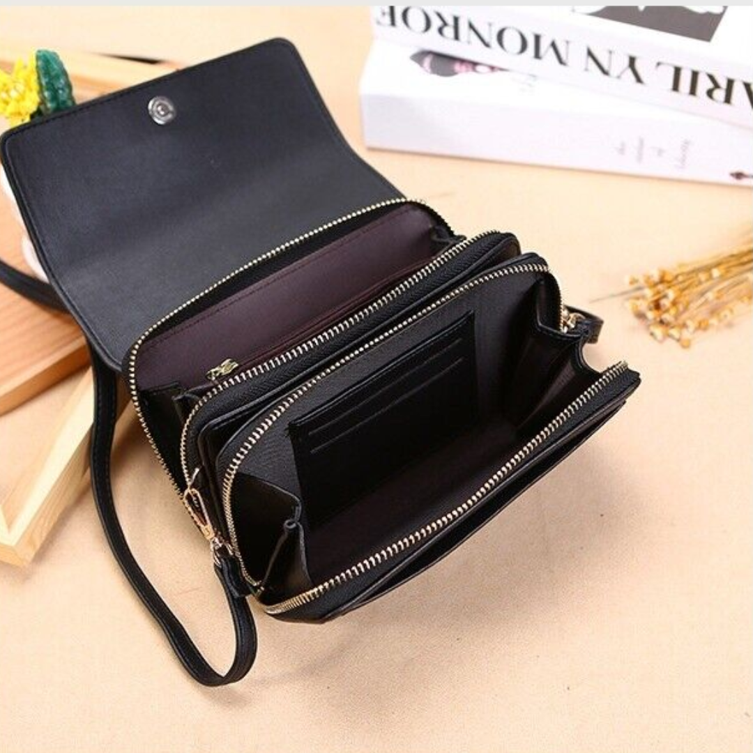 Black Fitlybuy leather crossbody bag with multiple zippered compartments and internal card slots, open on a desk.