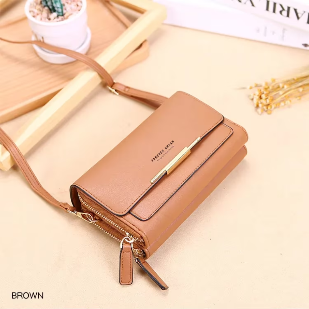 Brown leather Fitlybuy crossbody bag with gold hardware and double-zip closure on a beige background.