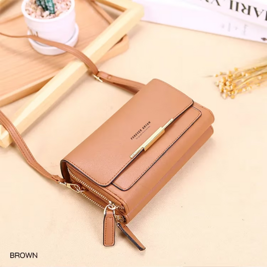 Brown leather Fitlybuy crossbody bag with gold hardware and double-zip closure on a beige background.