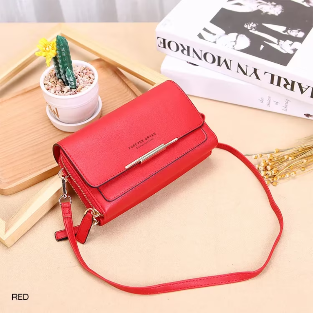 Red leather crossbody bag by Fitlybuy with gold hardware, displayed on a wooden tray with decor.