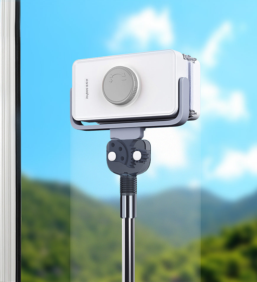 White, dual-sided magnetic window cleaner with extendable telescopic pole, cleaning a window with a mountain view.