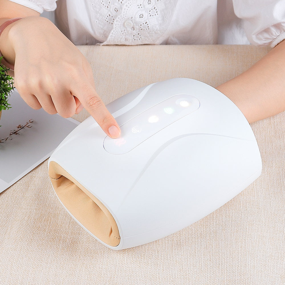 White Fitlybuy hand massager with tan interior, featuring air pressure and heat, operated by finger on a table.