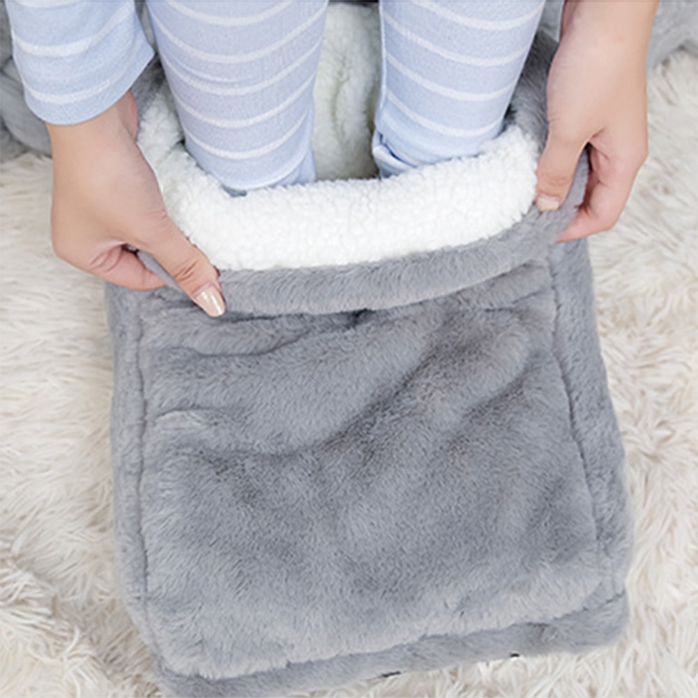 Person with legs in a grey, plush electric foot warmer with white sherpa interior for rapid heat comfort.
