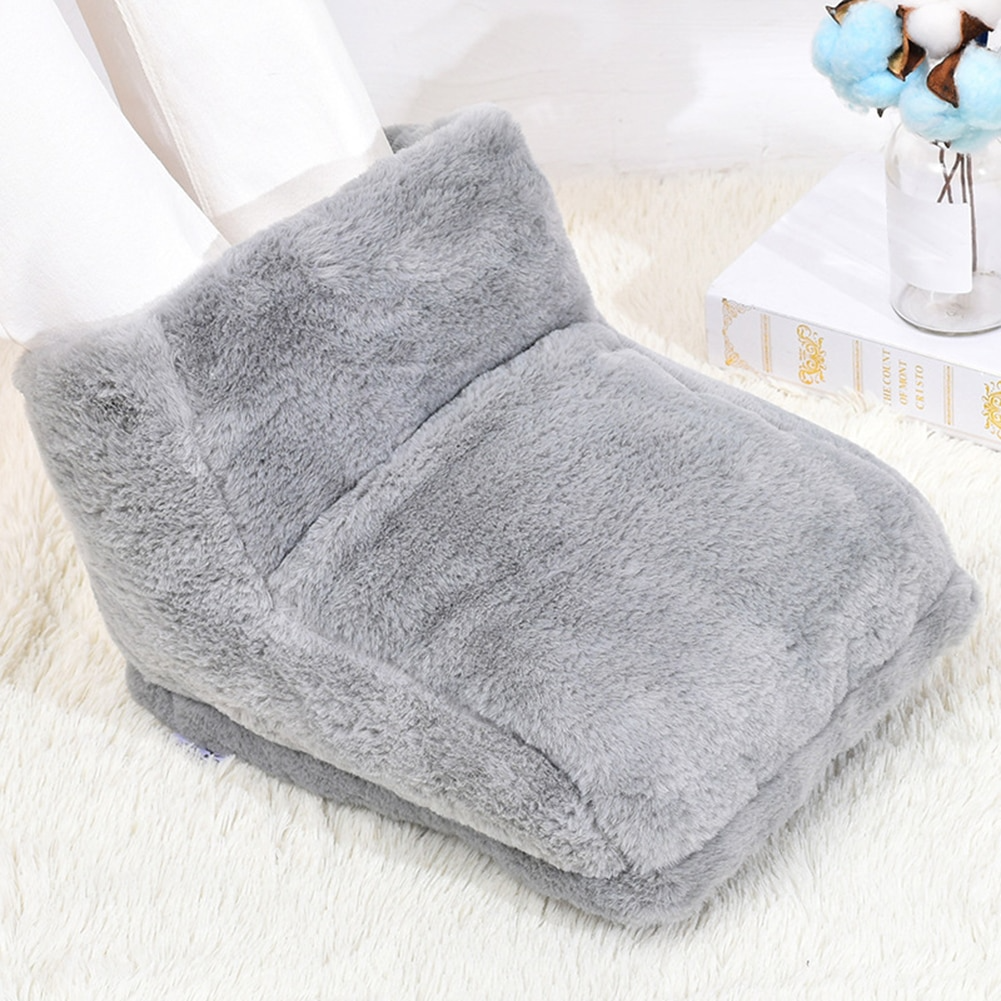 Plush gray Fitlybuy electric foot warmer with legs inserted, resting on a white fuzzy rug with decorative accents.