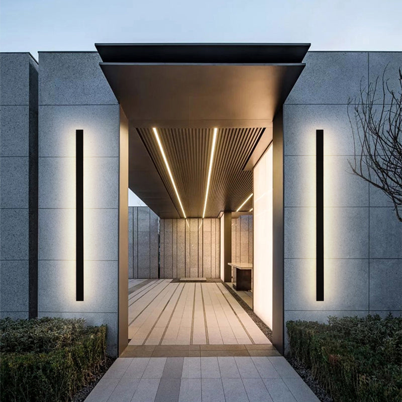 Fitlybuy minimalist black vertical LED wall lights mounted on a modern grey stone entrance of a contemporary home.