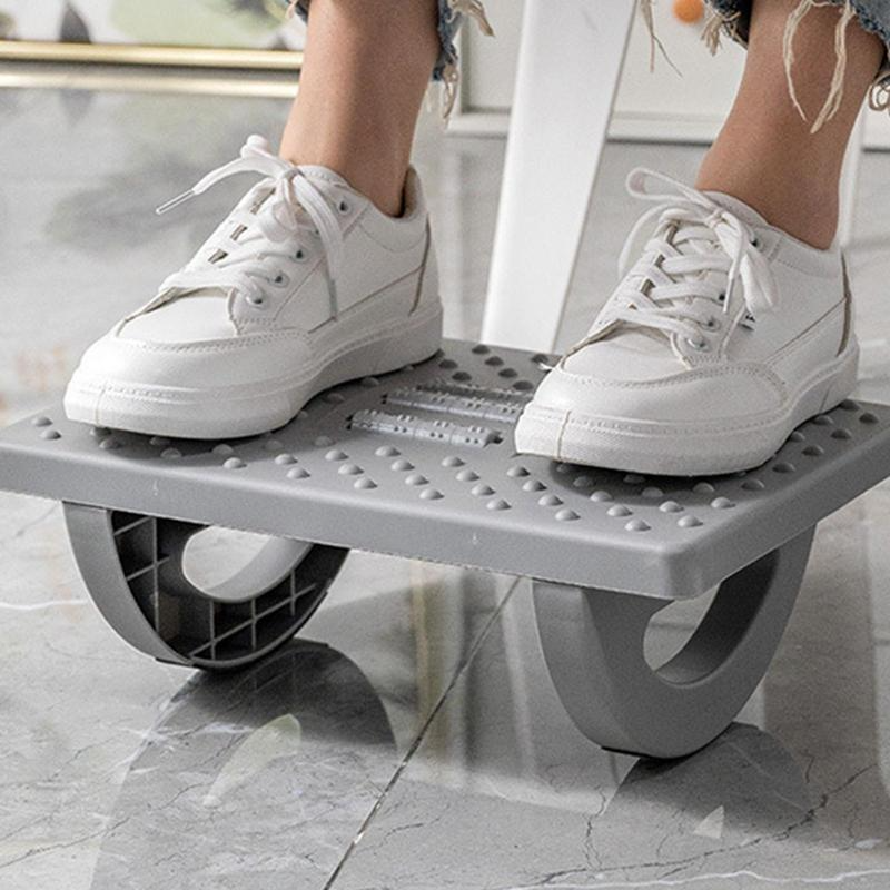 Person using a grey, textured Fitlybuy ergonomic rocker footrest stool under their feet for adjustable desk support.