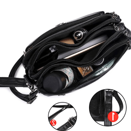 Fitlybuy Fosh black leather shoulder bag, top-down view showing multiple zippered compartments holding daily essentials.
