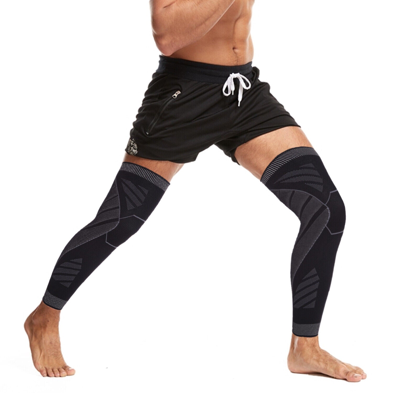 Person wearing black and grey Fitlybuy full leg compression sleeves with ergonomic support patterns against white.