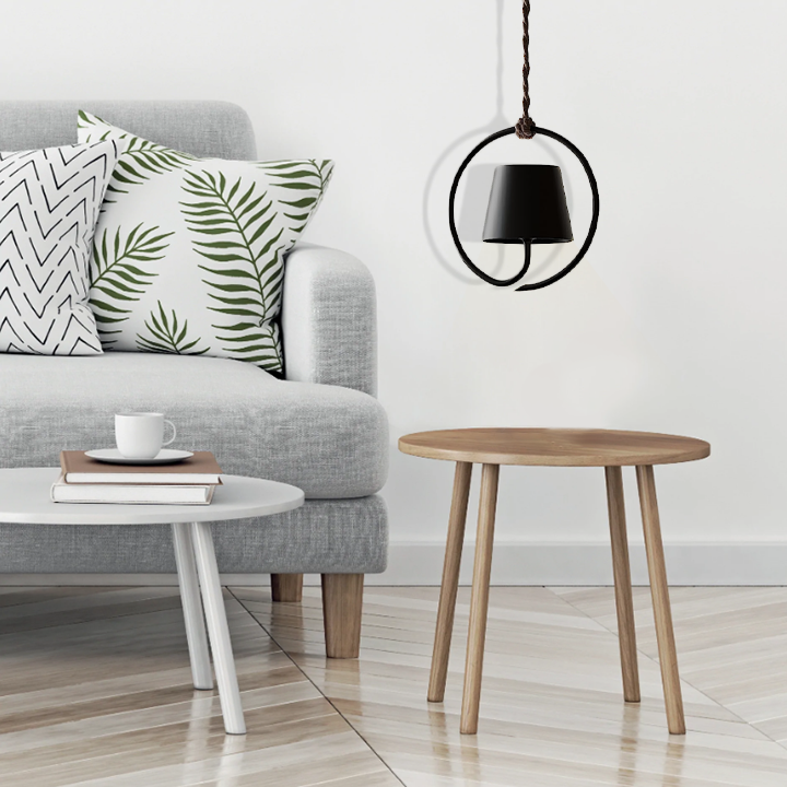 Fitlybuy LumiCord black LED hanging lamp with rechargeable tech suspended above a wooden side table in a modern living room.