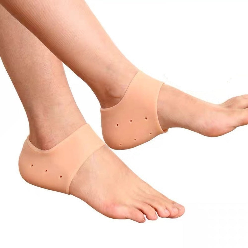 Fitlybuy nude silicone heel protector pads with breathable air holes worn on both feet for cushioning and comfort.