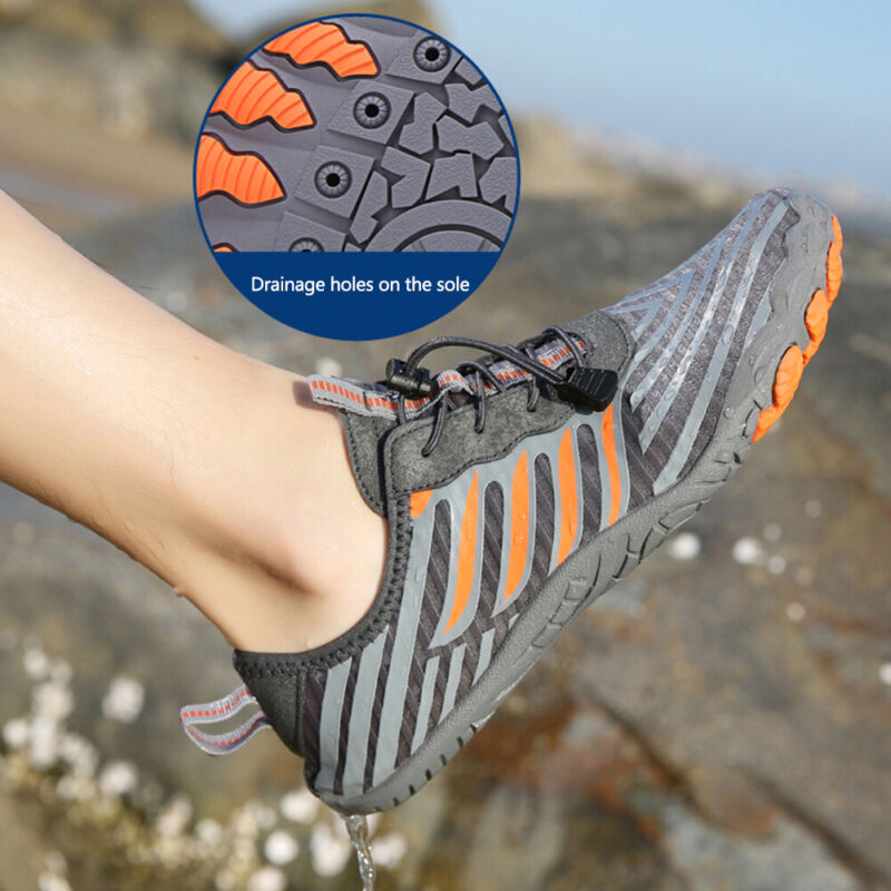 Fitlybuy grey and orange barefoot shoes with elastic laces and non-slip soles featuring drainage holes on a rocky beach.