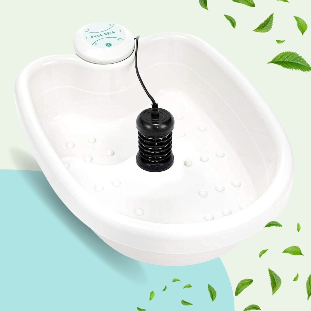 White ionic foot spa basin with a black detox array and control unit, set against a light background with green leaves.
