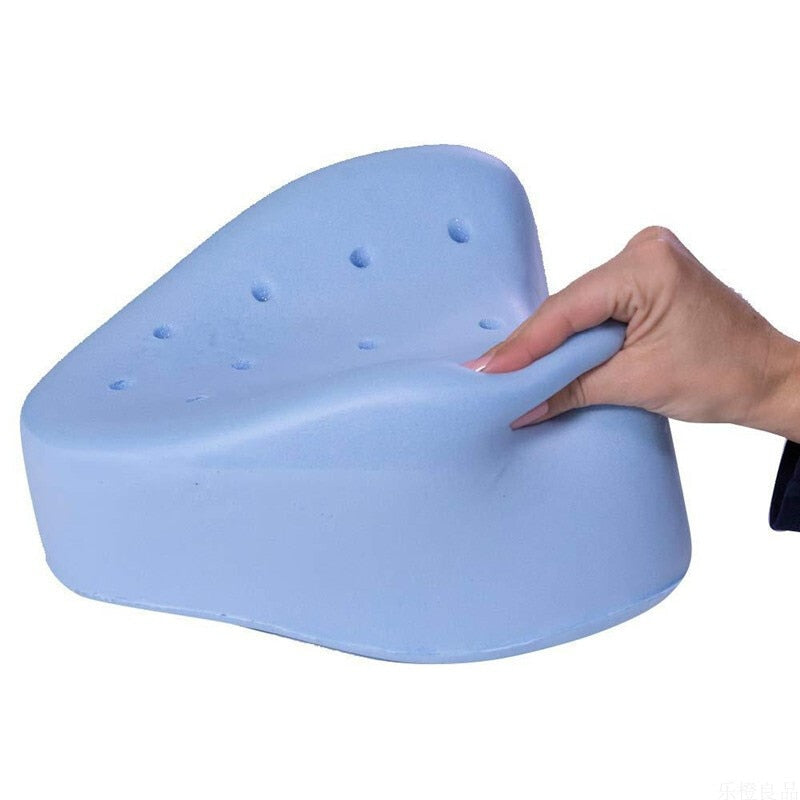 Hand pressing a blue Fitlybuy memory foam knee pillow with an ergonomic design and breathable aeration holes.