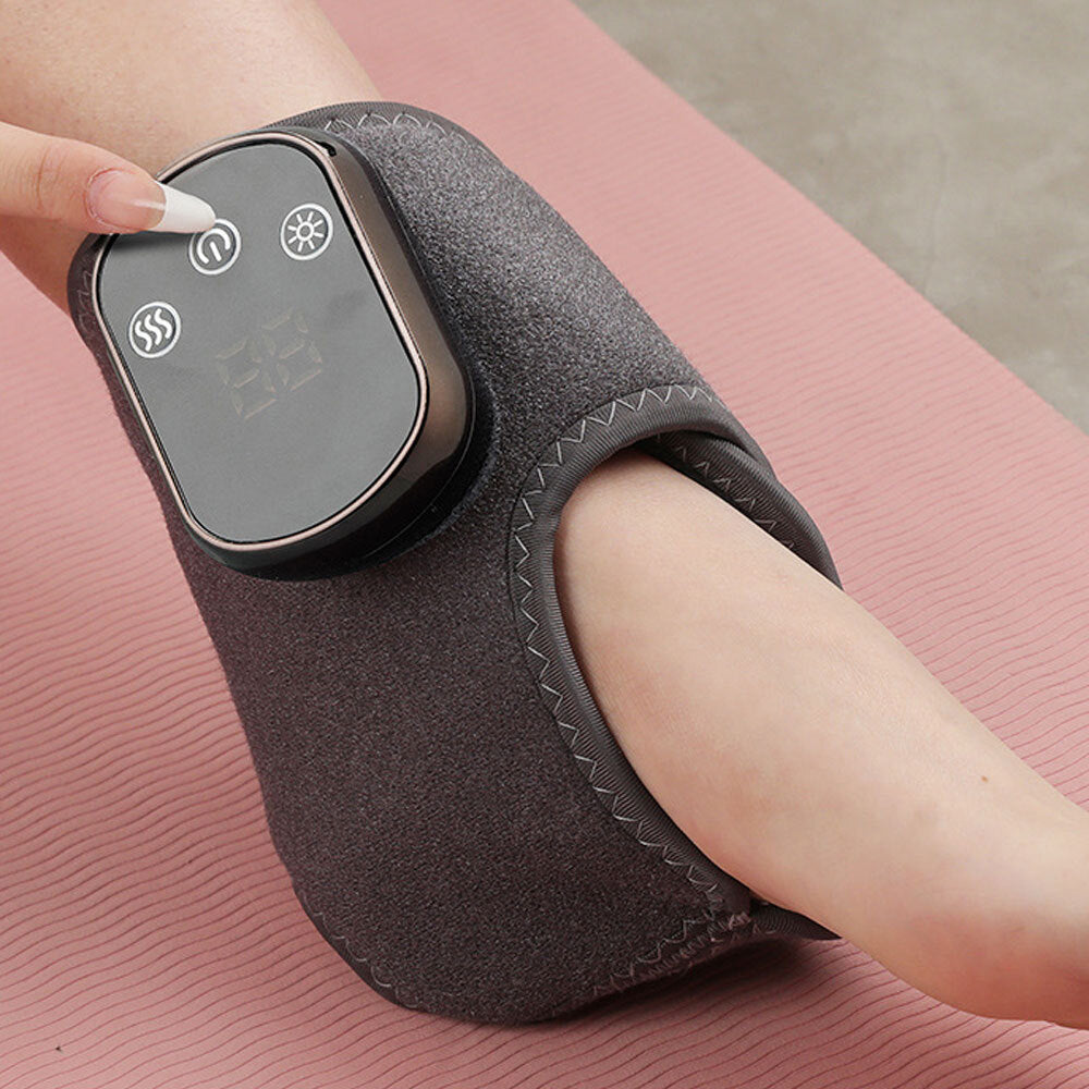 Fitlybuy grey heated ankle therapy wrap with digital control panel worn on a person's foot over a pink yoga mat.