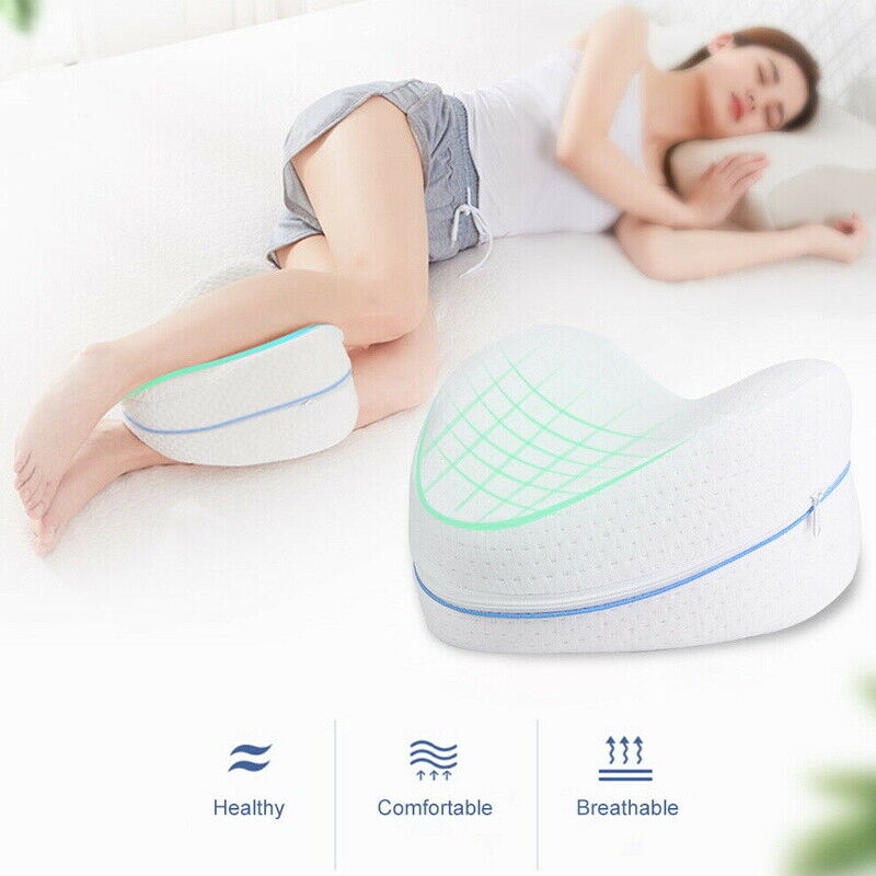 Fitlybuy white memory foam knee pillow with blue zipper, used between legs by a sleeping woman on a white bed.