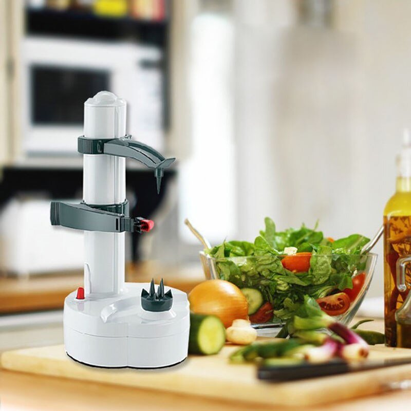 Fitlybuy electric peeler in white with gray arms on a kitchen counter next to a bowl of fresh salad.