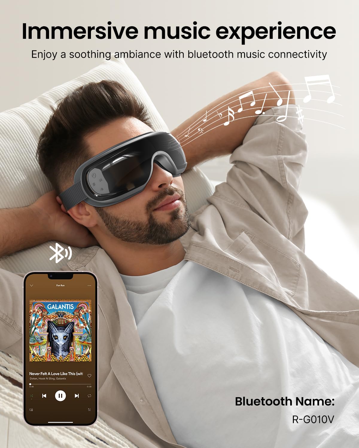 Man wearing gray Fitlybuy Eyeris 3 eye massager with Bluetooth, relaxing on a chair with music streaming from a phone.