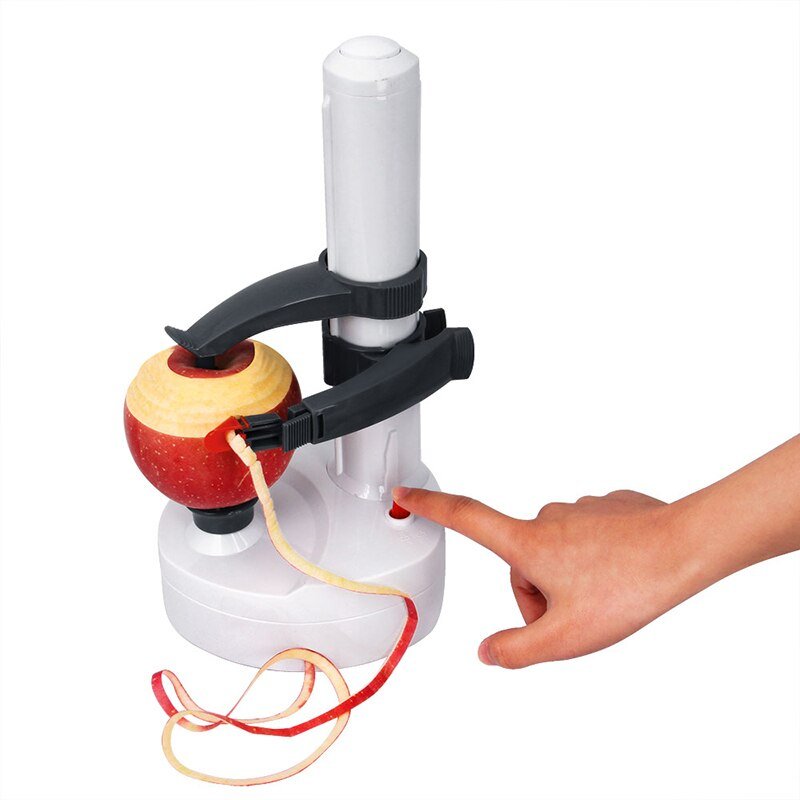 White Fitlybuy automatic electric peeler removing peel from a red apple, activated by a hand pressing a red button.