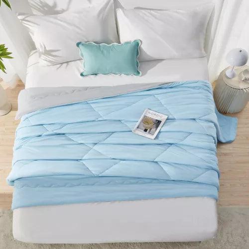 Fitlybuy Aussie Cool Ice Sleep Blanket in light blue ChillTech fabric with a diamond-stitched quilt pattern on a bed.