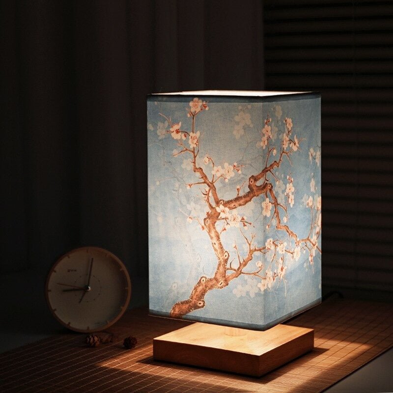 Fitlybuy Kyomi bamboo lamp with blue fabric shade featuring a white cherry blossom pattern, glowing on a table.