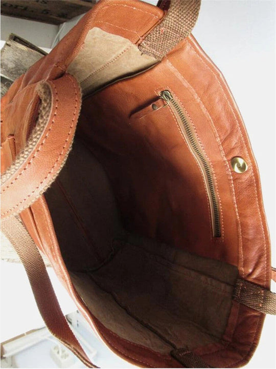 Interior view of a tan leather Fitlybuy Eva handbag showing a zipper pocket, fabric lining, and sturdy brown straps.