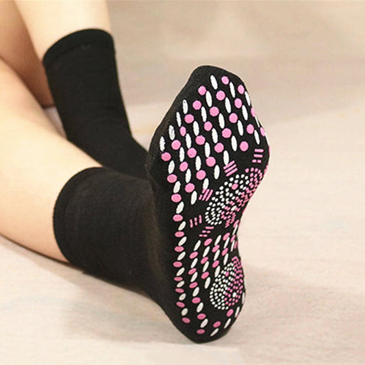 Black Fitlybuy self-heating magnetic socks with pink and white grip dots on the sole, worn on feet.