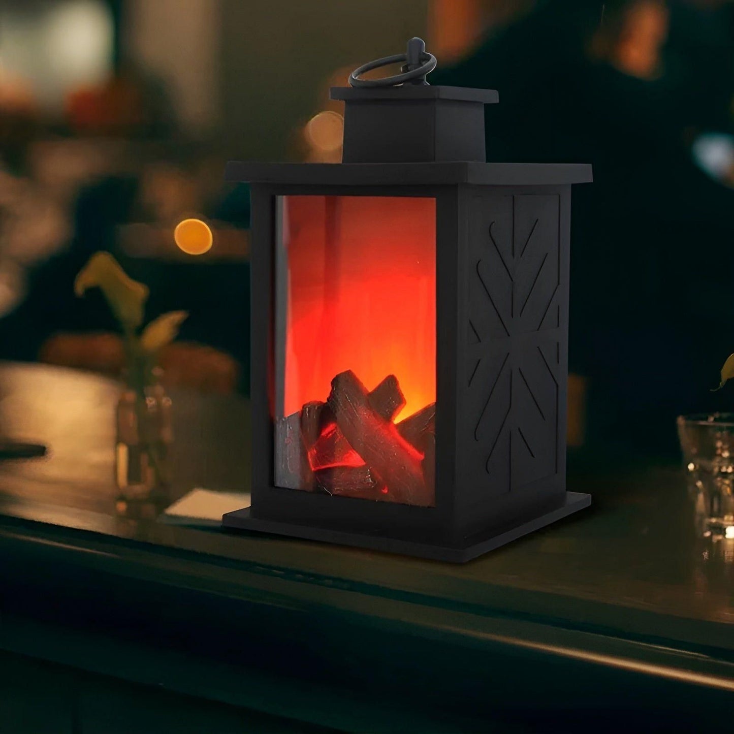Black Fitlybuy RadiantFlame LED lantern with realistic glowing logs on a table, creating cozy, warm ambient lighting.