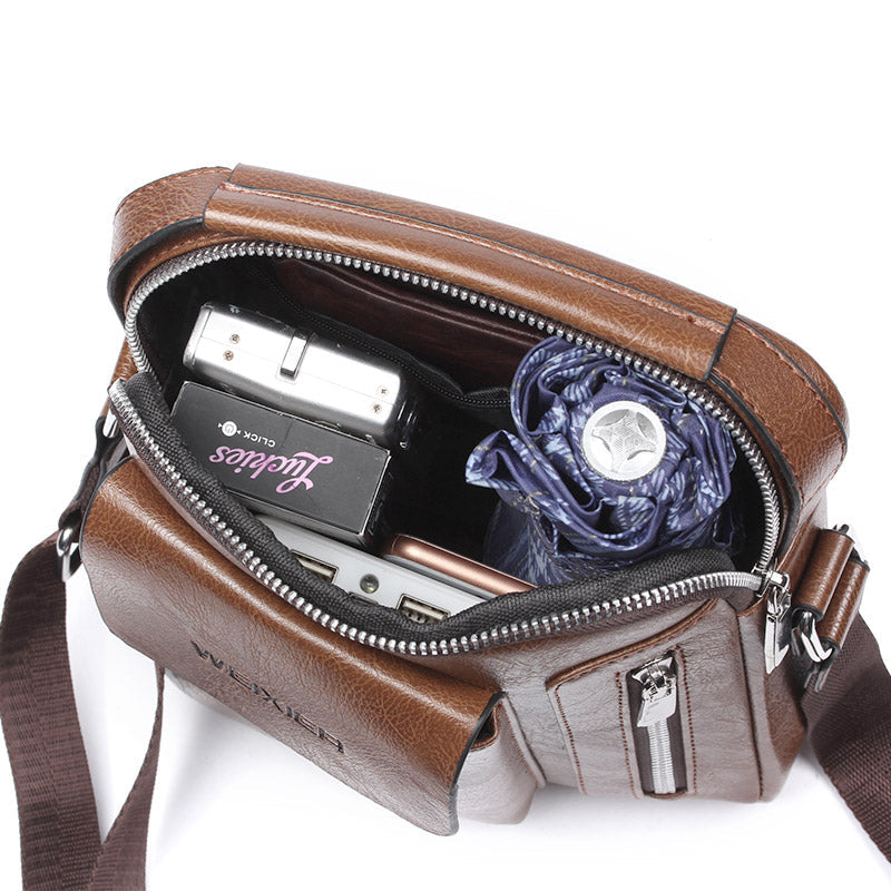 Brown PU leather shoulder bag for men, open with visible main compartment, side pockets, and adjustable crossbody strap.