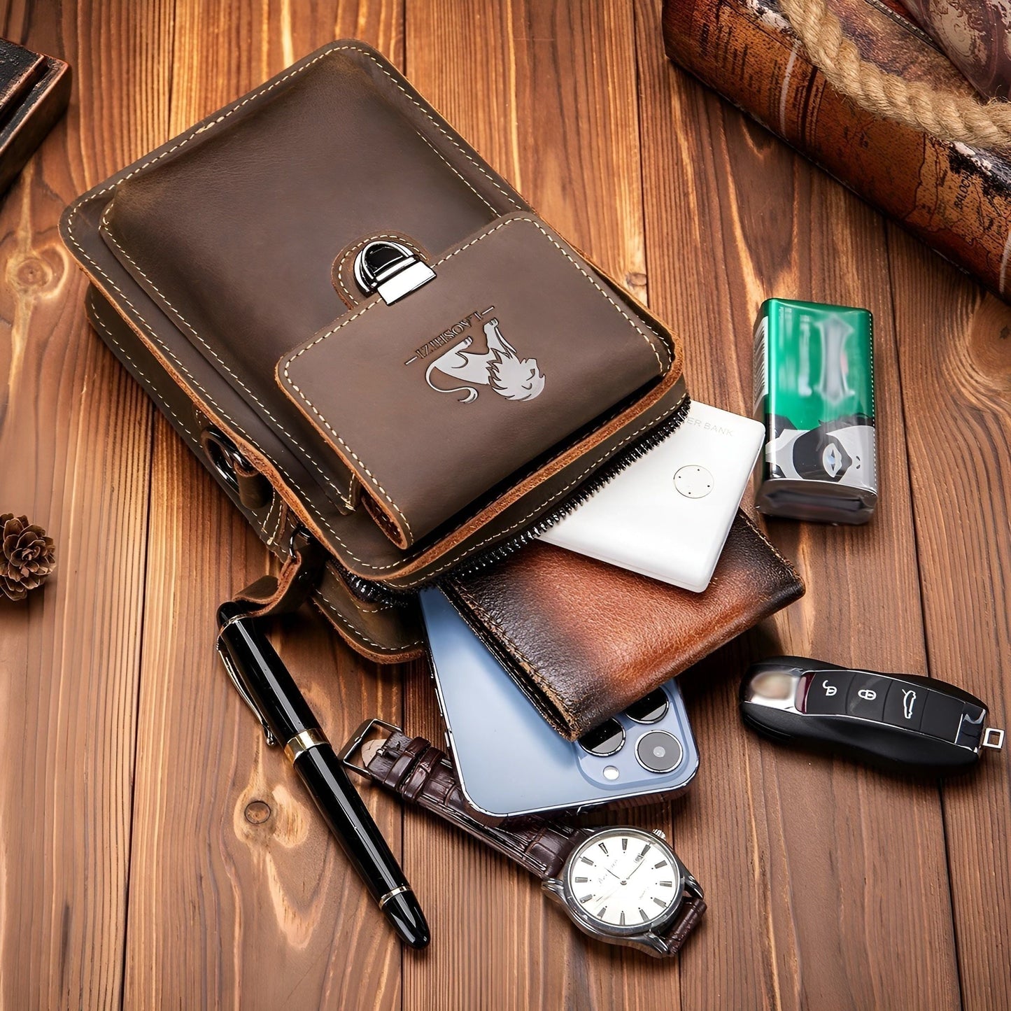 Brown leather Fitlybuy Vidal waist bag with lion logo, multi-pocket design, on wood background with personal accessories.
