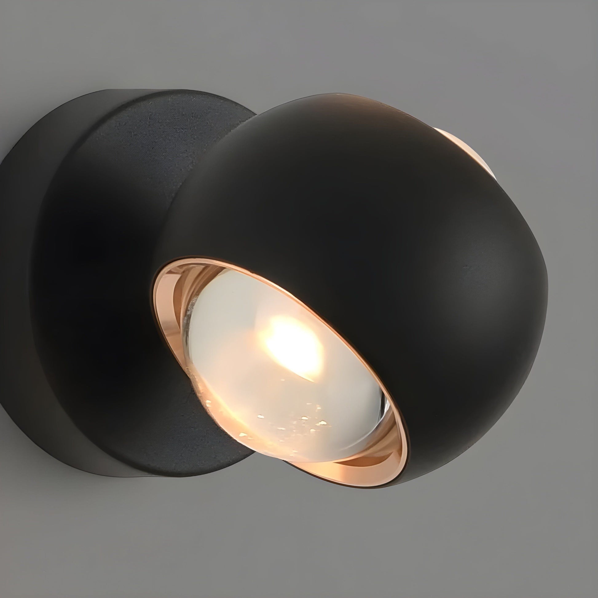 Fitlybuy ModernEdge rotating wall light with a matte black spherical design, rose gold trim, and glowing LED bulb.