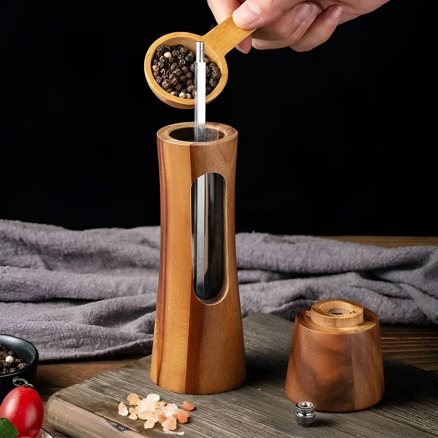 Fitlybuy wooden salt and pepper mill being refilled with peppercorns, featuring a sleek, elegant natural wood design.
