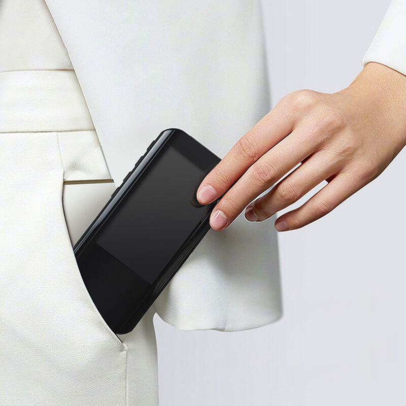 Fitlybuy compact black smart digital multimeter being placed into a pocket by a hand in a white blazer.