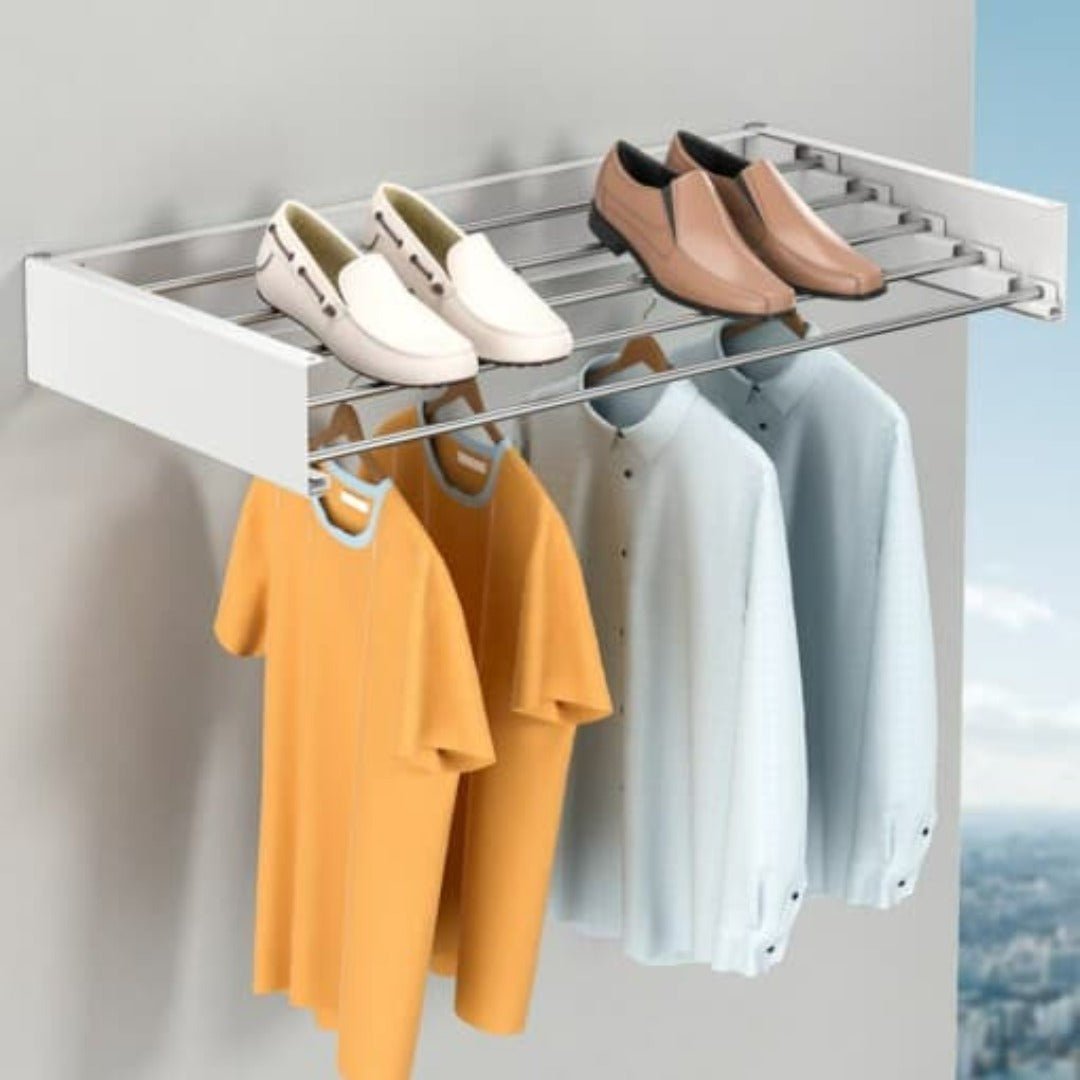 Fitlybuy white, wall-mounted folding drying rack holding shirts on hangers and shoes on the top metal shelf.