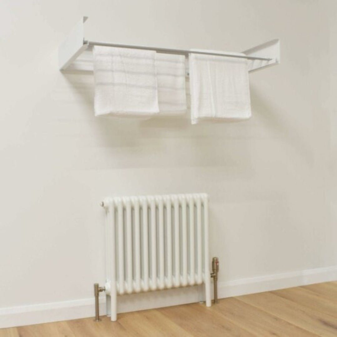 White foldable wall-mounted drying rack holding two white towels above a wall radiator.