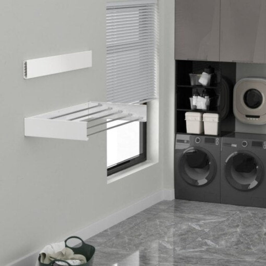 White foldable wall-mounted drying rack installed in a modern laundry room with grey appliances.
