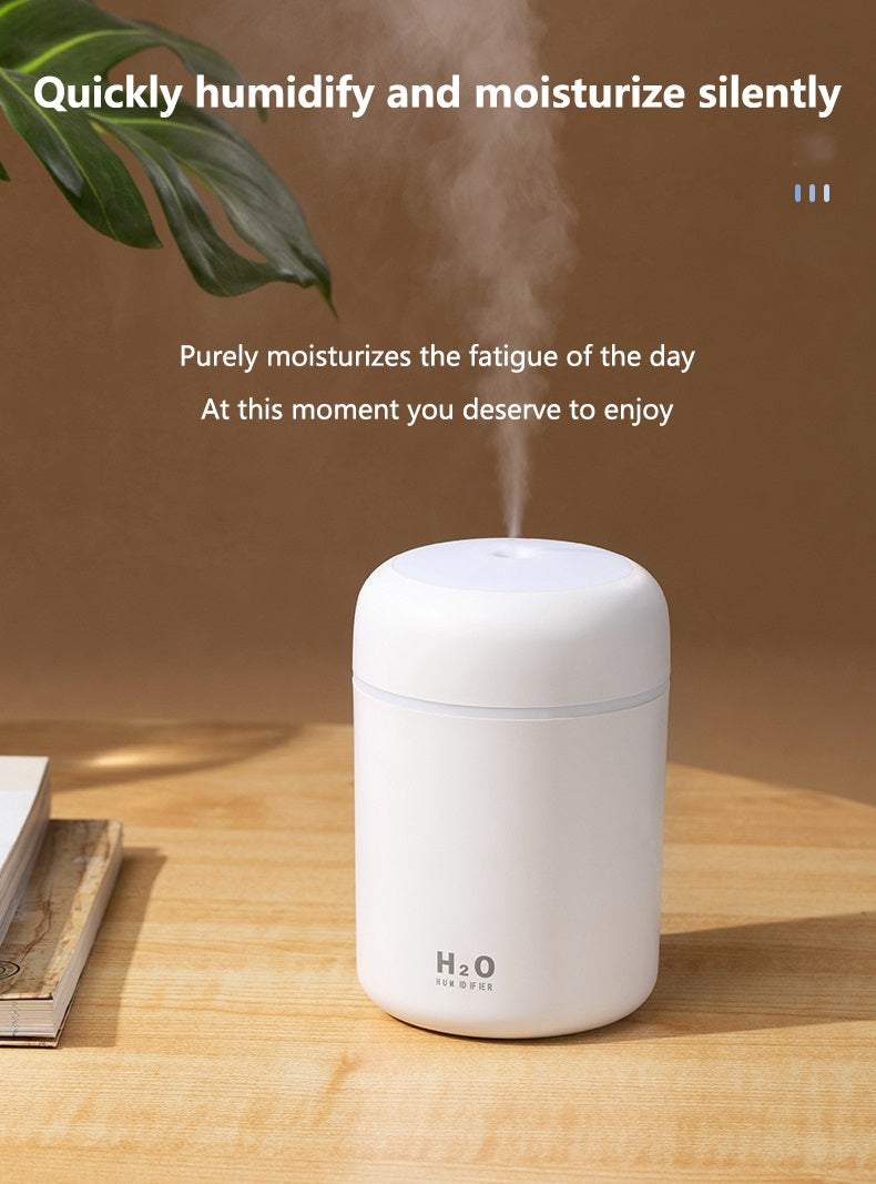 White Fitlybuy portable aroma diffuser with UltraMist technology, emitting vertical steam on a wooden table.