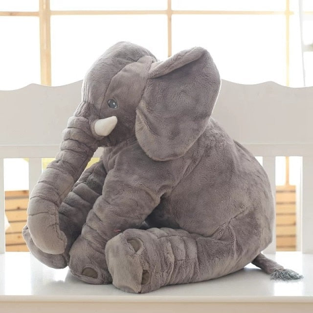 Gray plush elephant pillow with soft fur sitting on a white bench, perfect for babies and kids.