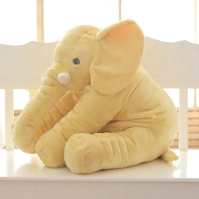 Fitlybuy yellow plush elephant pillow for kids. Soft, cuddly toy seated on a white bench, side view.