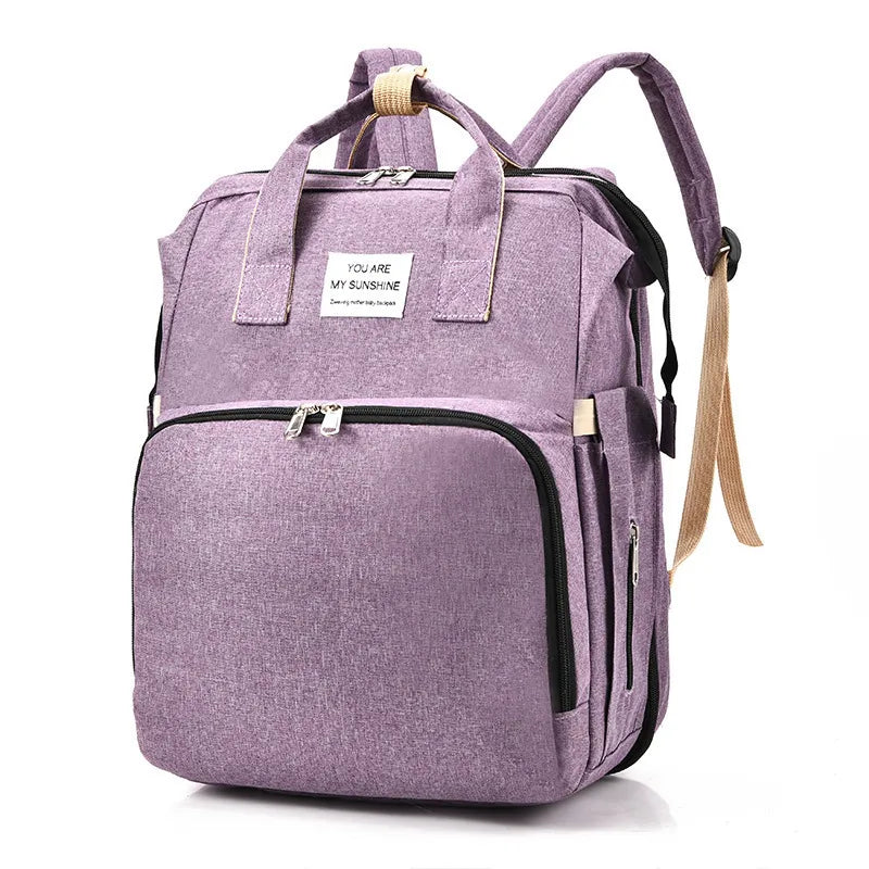Purple Fitlybuy smart nappy backpack with USB port, waterproof fabric, and tag reading "You Are My Sunshine."