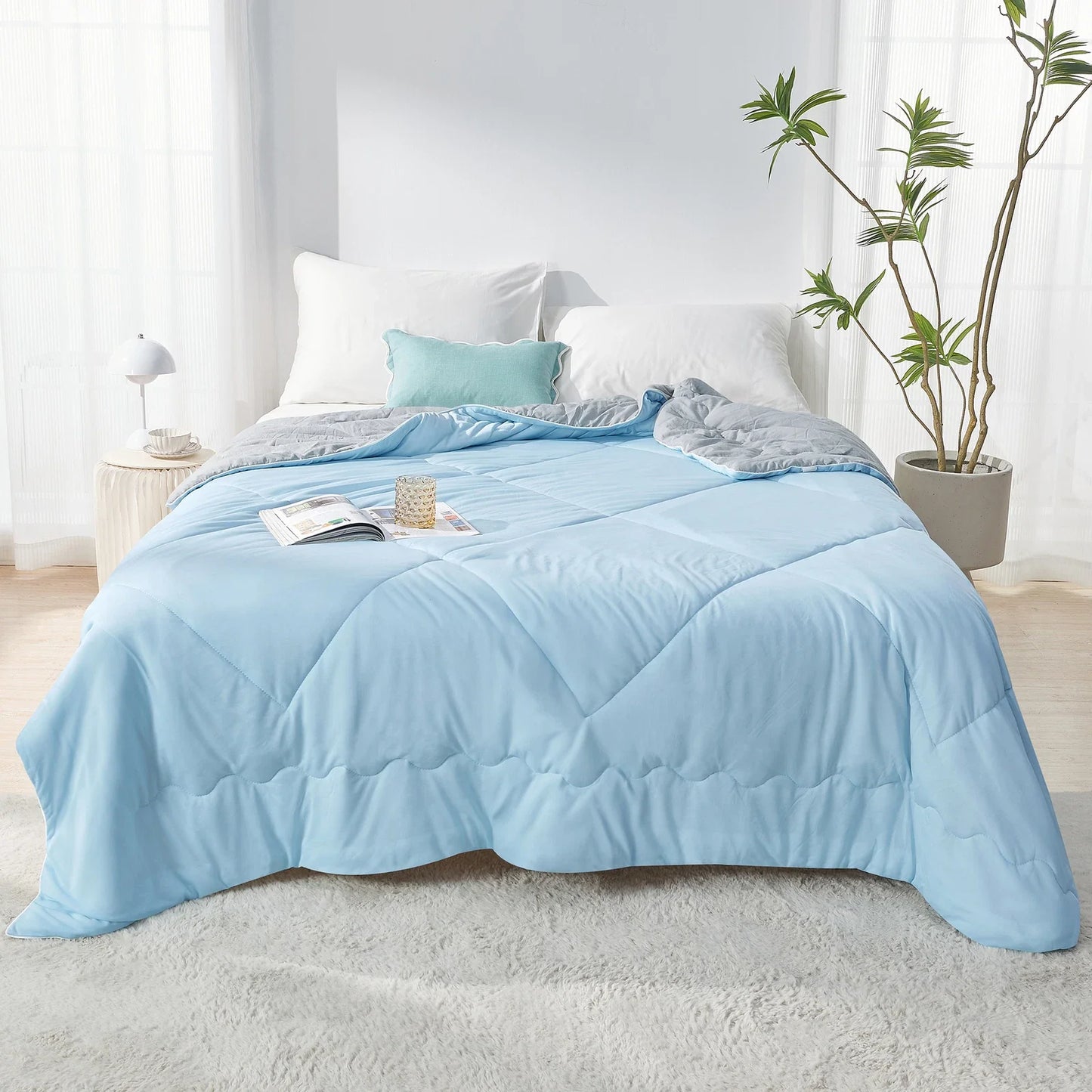 Fitlybuy Aussie Cool Ice quilt in light blue and grey ChillTech fabric, draped on a bed in a bright, modern bedroom.