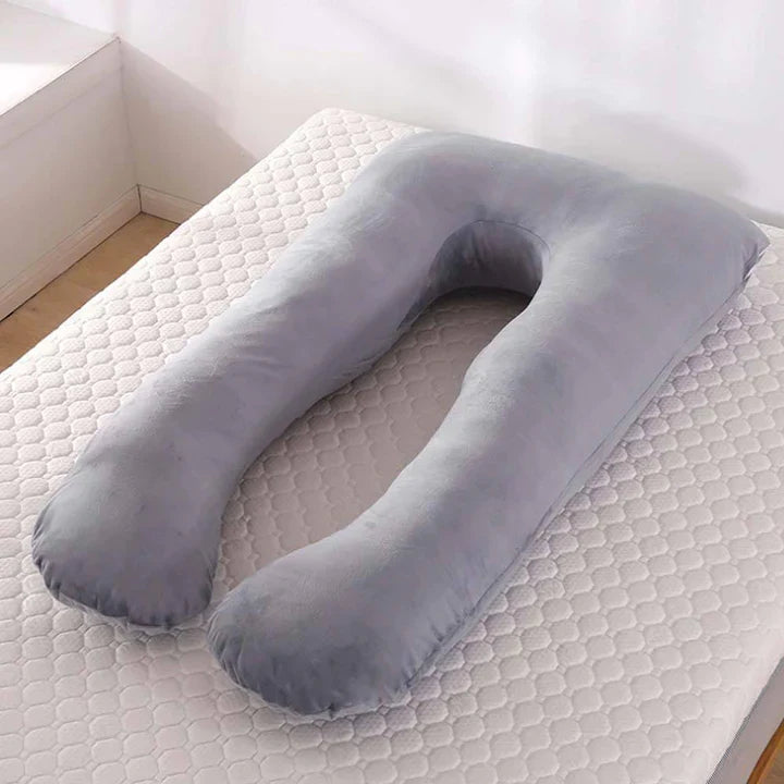 Gray U-shaped Fitlybuy pregnancy body pillow on a white mattress, offering full-body adaptive support.