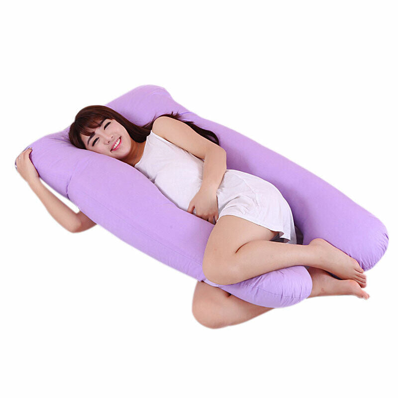 A woman smiling while resting in a large, purple U-shaped Fitlybuy full-body pregnancy pillow on a white background.