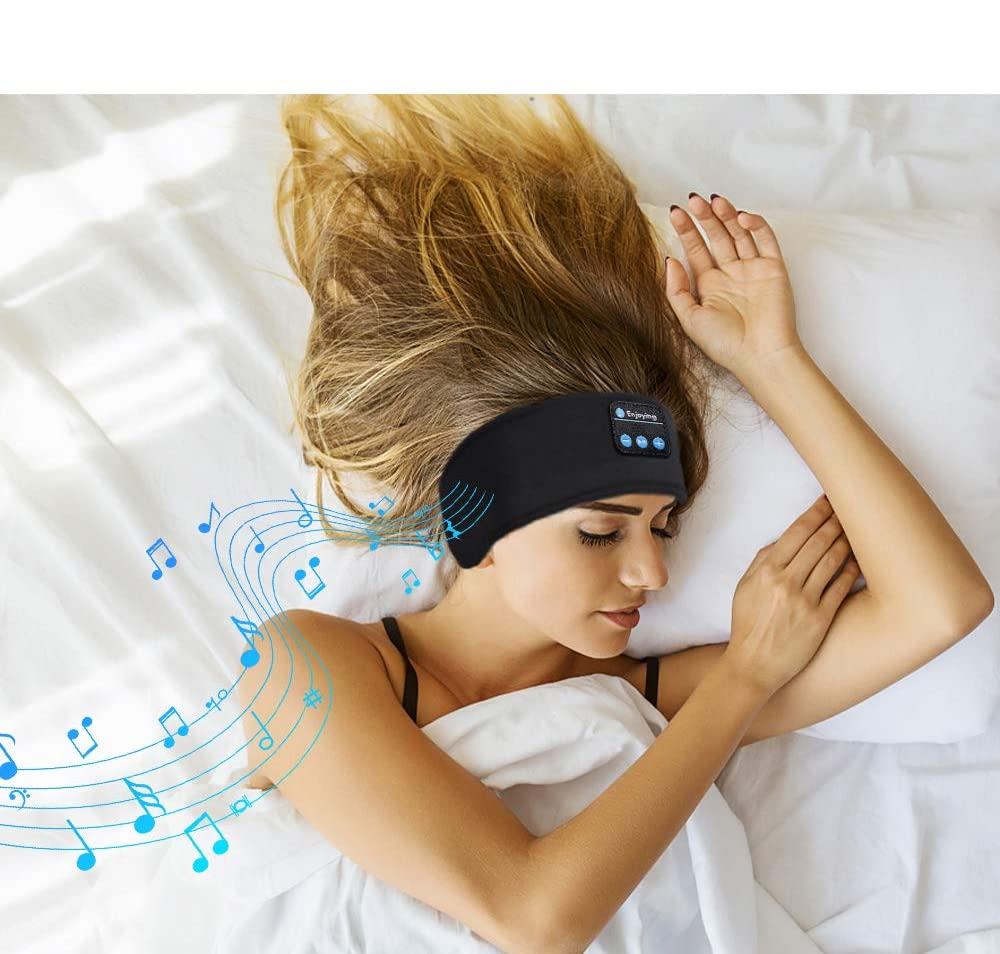 Woman sleeping in a black memory foam Fitlybuy sleep headband with built-in Bluetooth controls and musical notes.