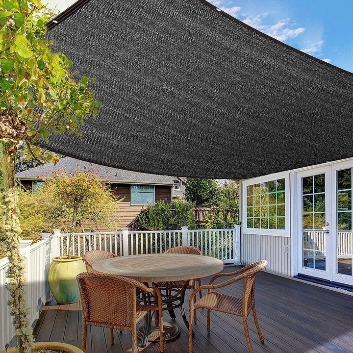 Fitlybuy black UV shade net installed over a wooden deck with outdoor furniture, providing shade on a sunny day.